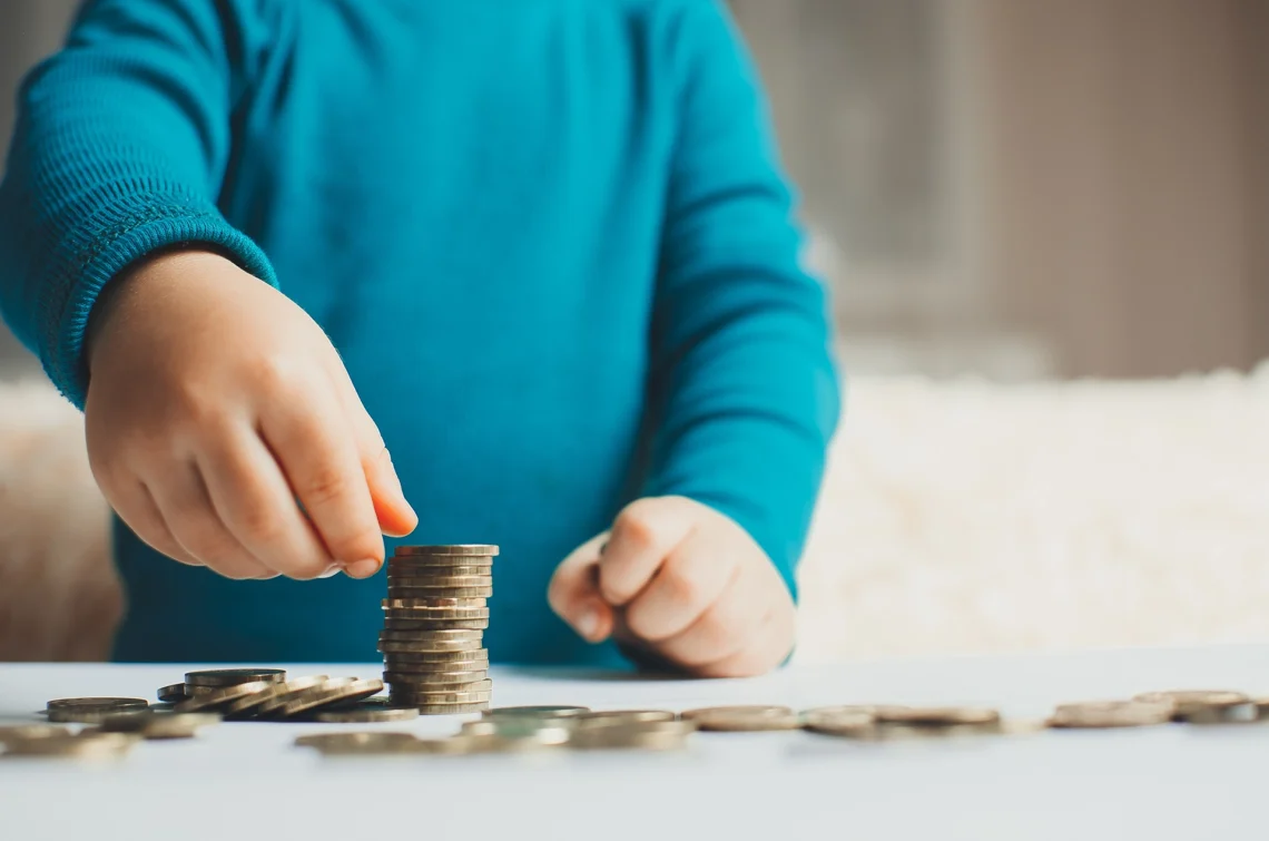 A child wearing a blue top counting money.