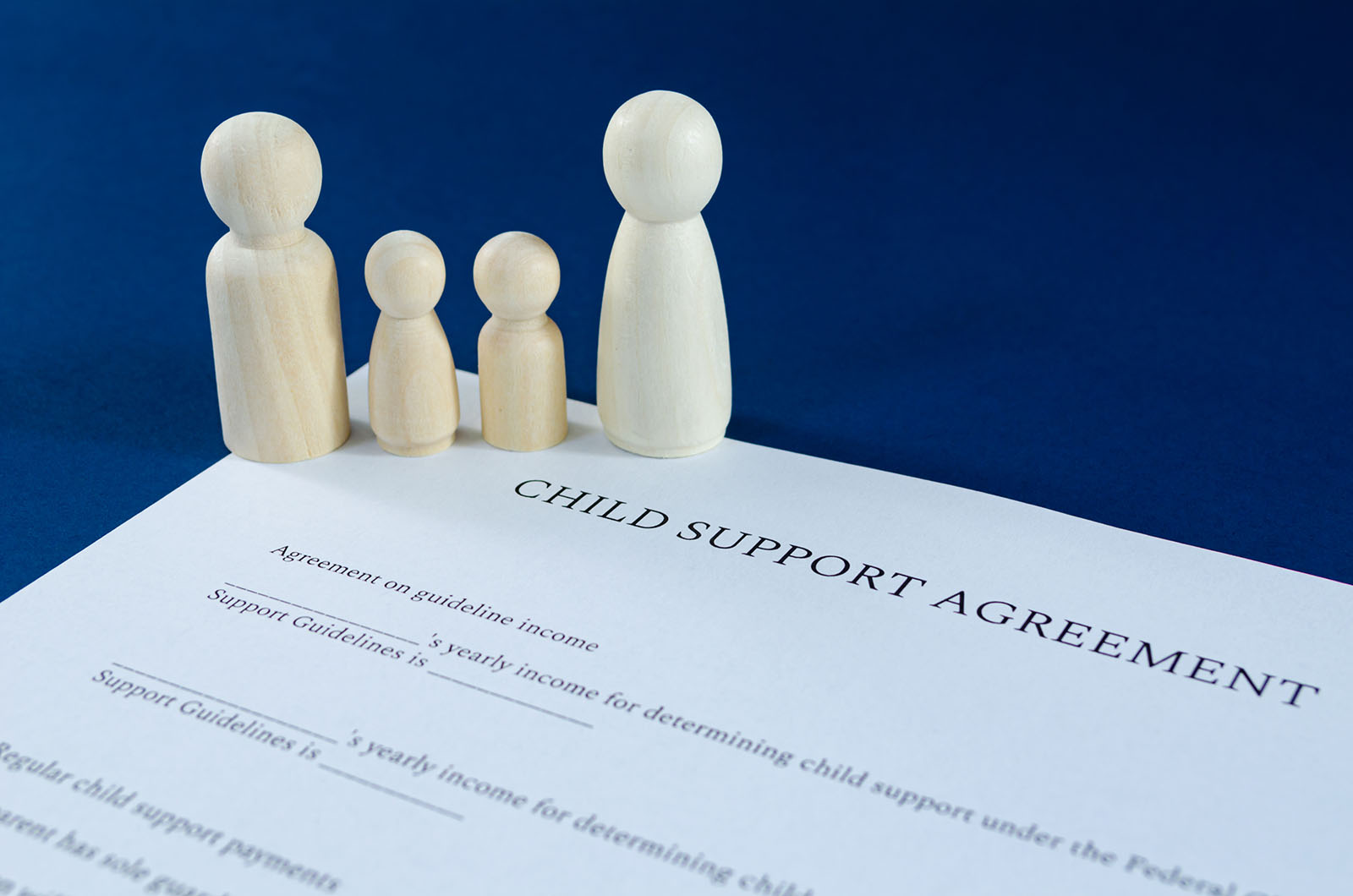 Family figurines standing over a child support agreement
